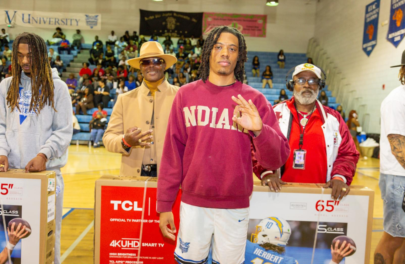 Kappa Alpha Psi members present television donation.