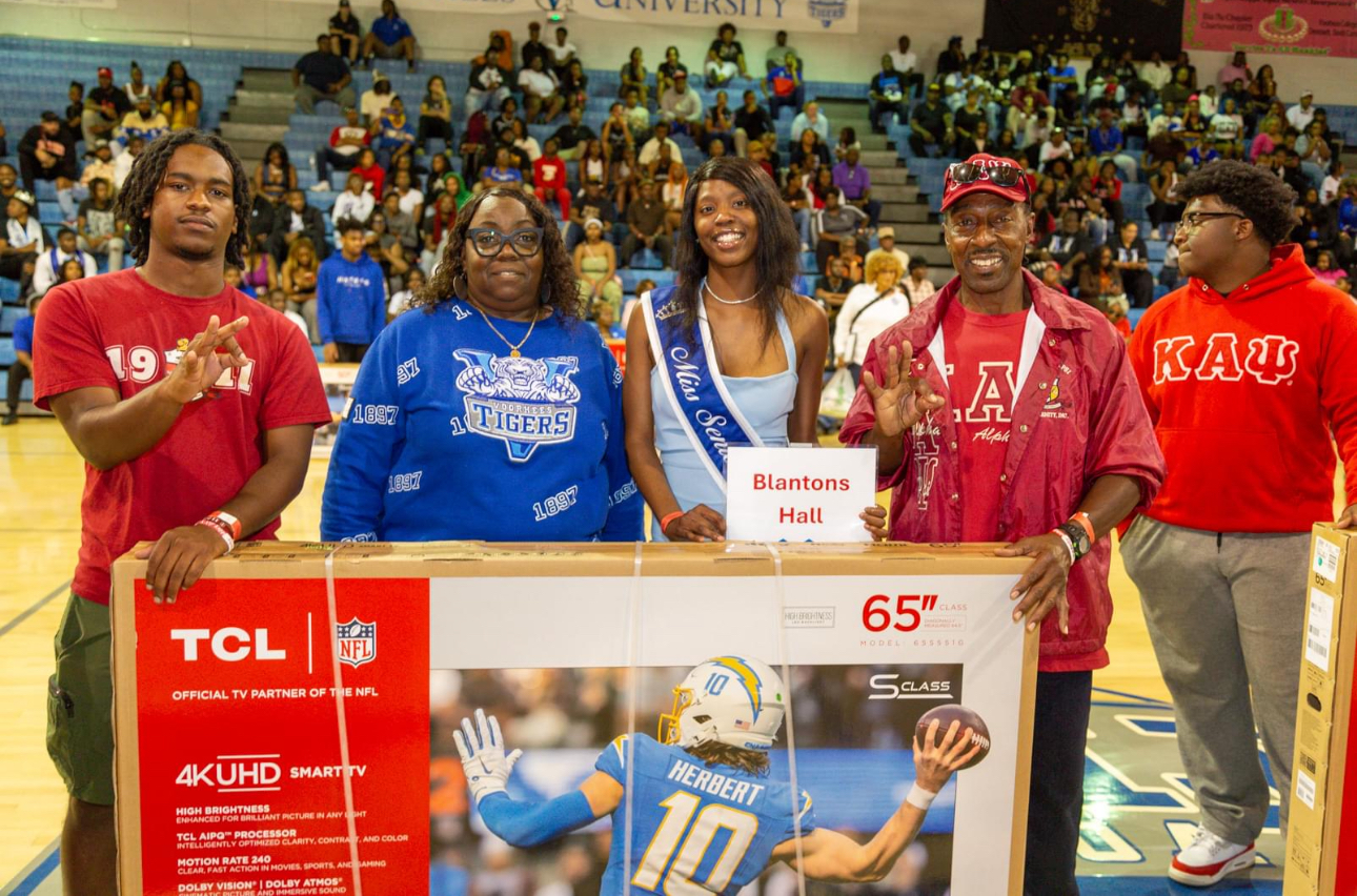 Kappa Alpha Psi members present television donation.