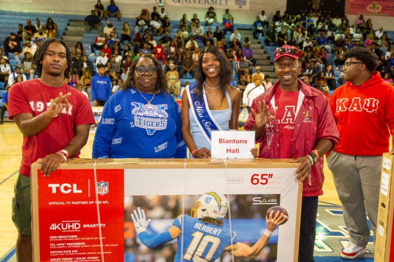 Kappa Alpha Psi members present television donation.