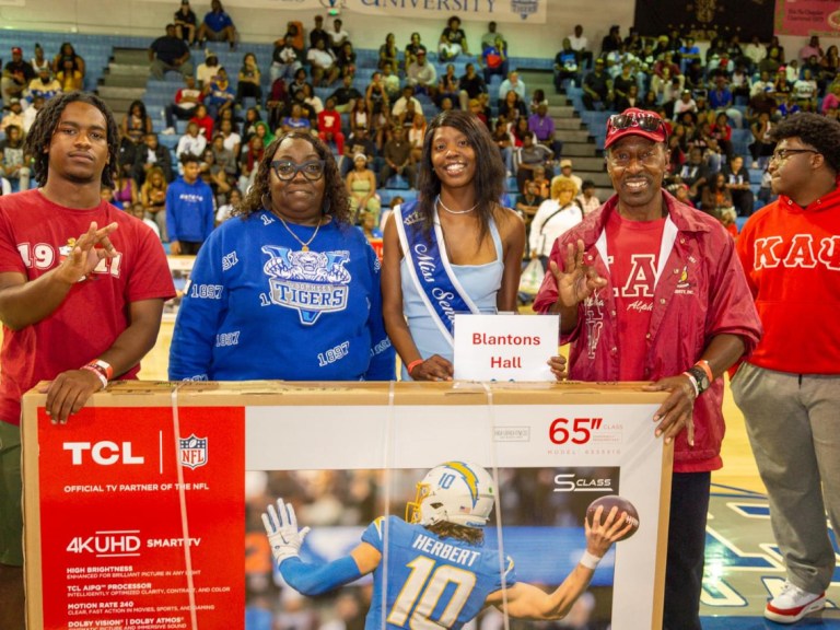 Kappa Alpha Psi members present television donation.