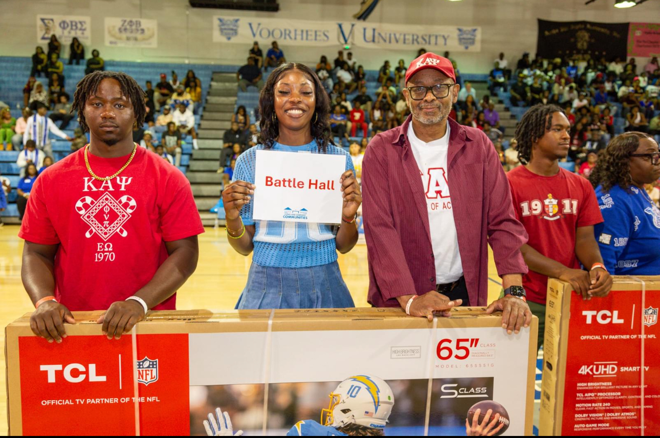 Kappa Alpha Psi members present television donation.